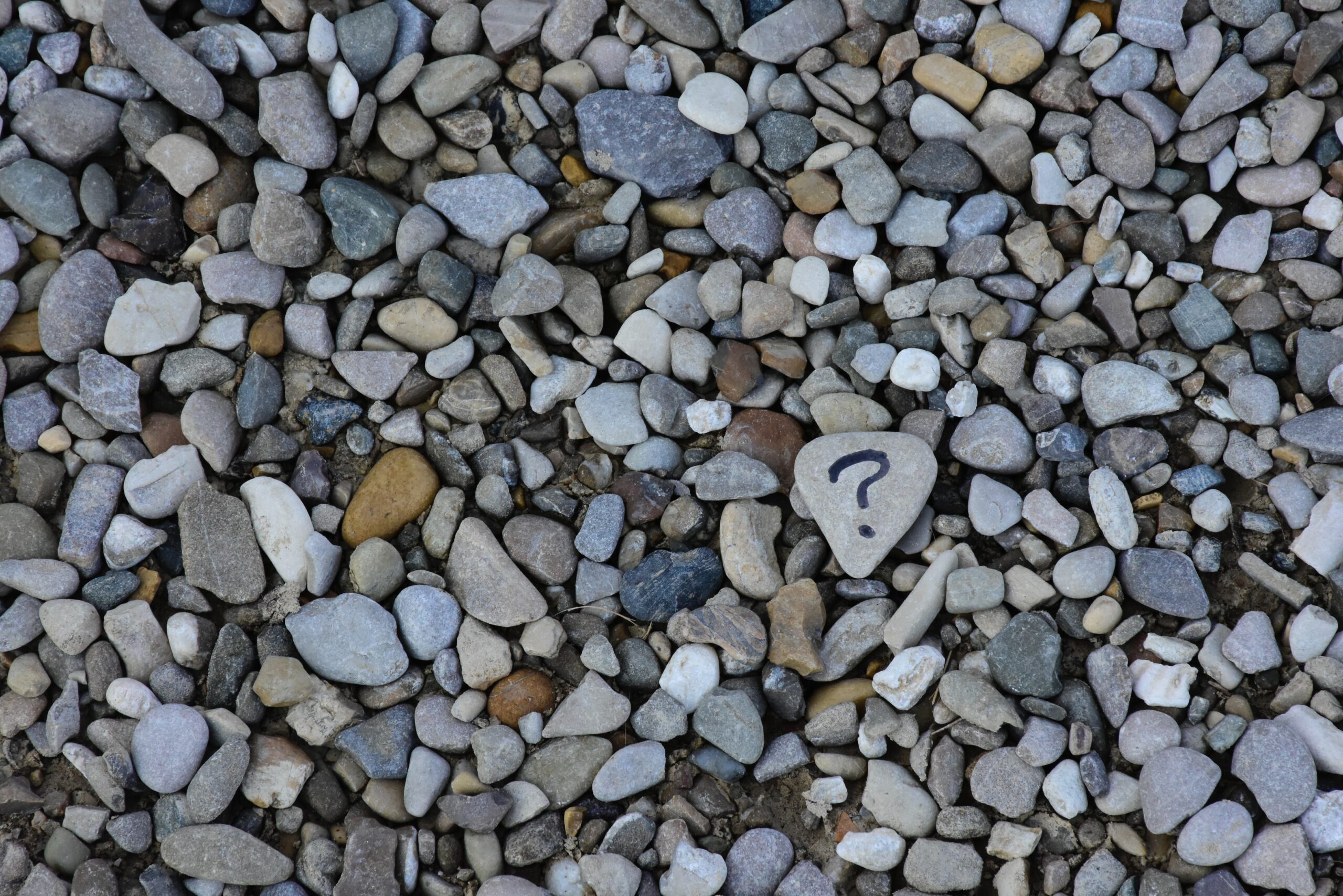 Many different stones, one with a question mark